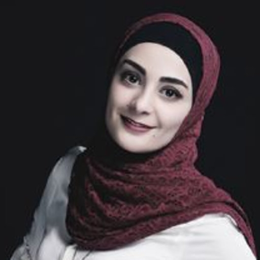 She is smiling wearing a red hijab